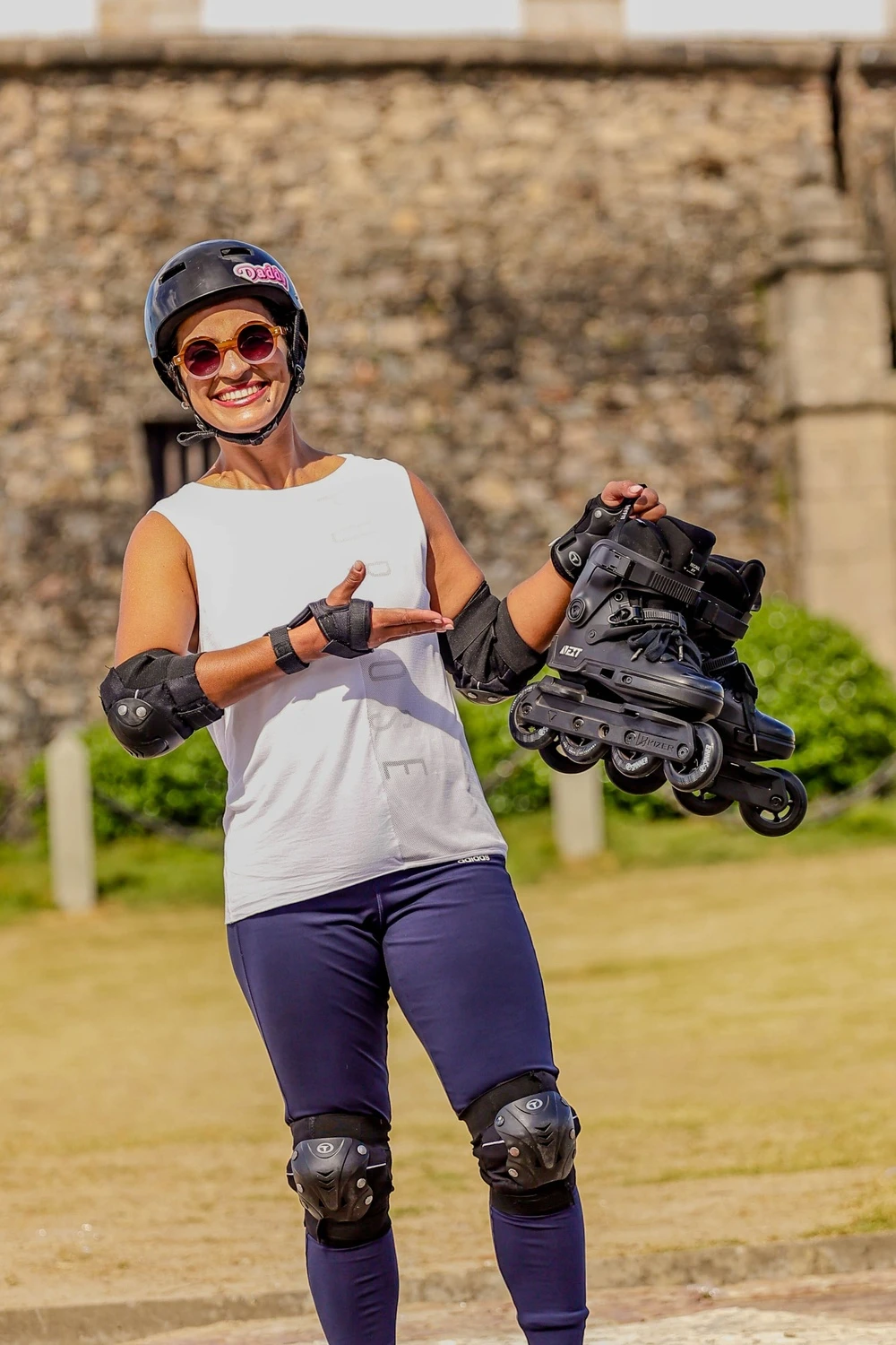 Lidiane Pinto sorrindo, de capacete e segurando seus patins